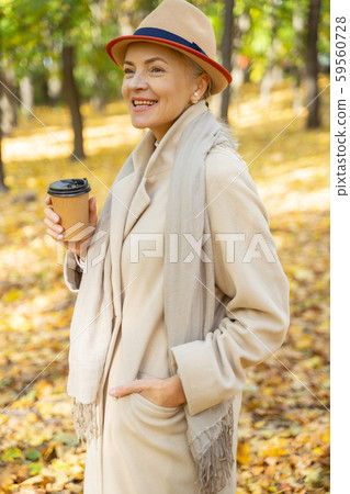 Cheerful woman with coffee staring into the distance 59560728