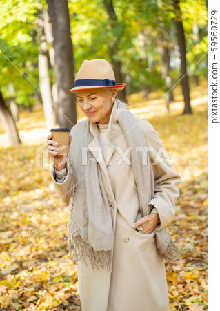 Cheerful modern woman relaxing in a park Cheerful modern woman relaxing in a park 59560729