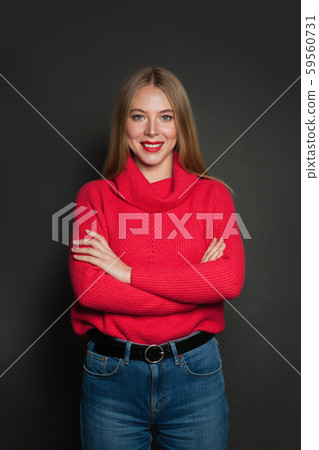 Smiling woman wearing red sweater on gray Smiling woman wearing red sweater on gray 59560731