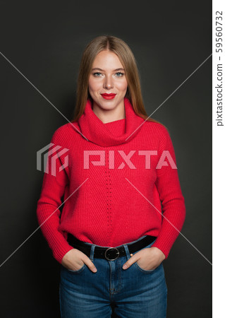 Cheerful woman in red sweater on gray background Cheerful woman in red sweater on gray background 59560732