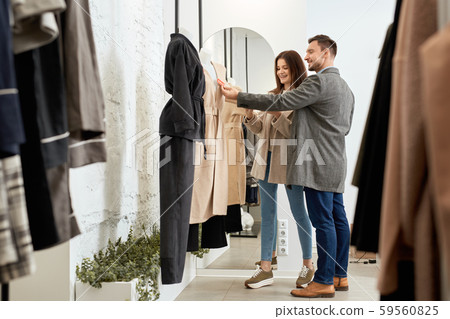 Adult woman and man checking price on clothes Adult woman and man checking price on clothes 59560825