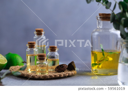 Set of glass bottles with eucalyptus essential oil on grey table leaves in vase Set of glass bottles with eucalyptus essential oil on grey table leaves in vase 59561019