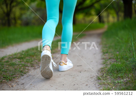 A young sports girl running in a quit green summer A young sports girl running in a quit green summer 59561212