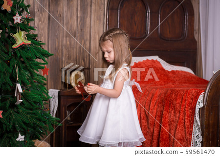 Little girl decorates a Christmas tree Little girl decorates a Christmas tree 59561470