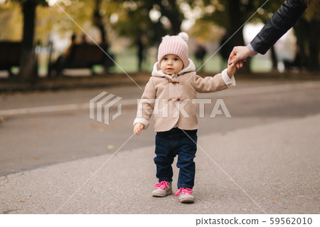 Cute little baby walking in the park with mother. Autumn Cute little baby walking in the park with mother. Autumn 59562010