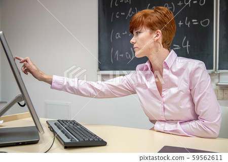 Young teacher lectures at the School of Mathematics, writes chalk on a blackboard 59562611