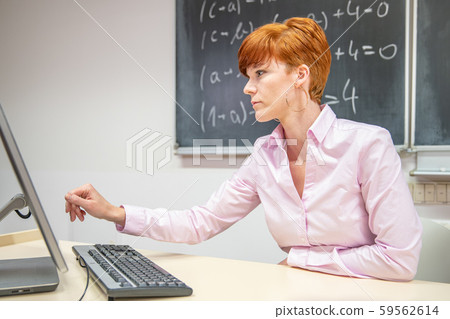 Young teacher lectures at the School of Mathematics, writes chalk on a blackboard 59562614