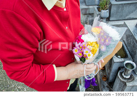 An elderly woman visiting an ancestor's grave An elderly woman visiting an ancestor's grave 59563771
