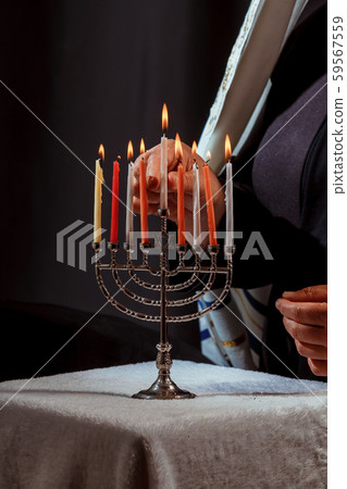 Man hand lighting candles in menorah hanukka 59567559
