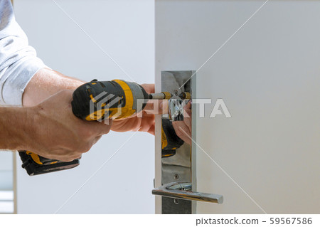 Carpenter fixing lock in door with home 59567586