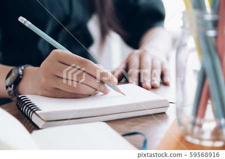 Close up female hands with pen writing on 59568916