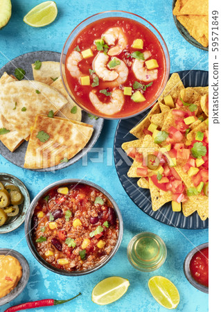 Mexican food, many dishes of the cuisine of Mexico, flat lay top-down shot from on a vibrant blue 59571849