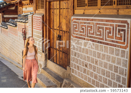 Young woman tourist in Bukchon Hanok Village is one of the famous place for Korean traditional Young woman tourist in Bukchon Hanok Village is one of the famous place for Korean traditional 59573143