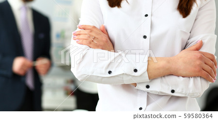 Arms of woman wearing formal clothes in office crossed on chest Arms of woman wearing formal clothes in office crossed on chest 59580364