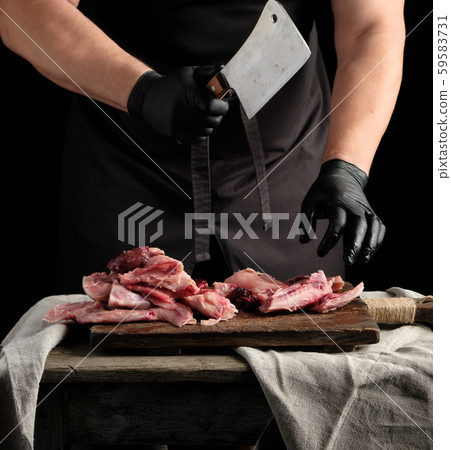 chef in black latex gloves holds a big knife and 59583731