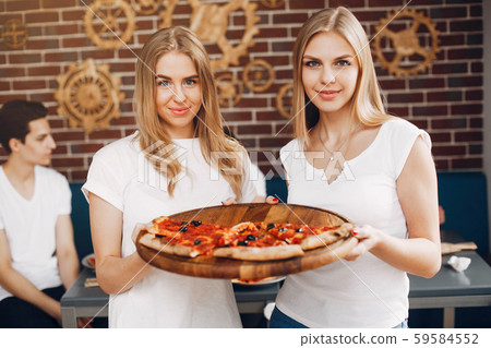 Cute friends in a cafe eatting a pizza 59584552