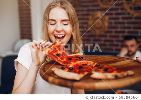 Cute friends in a cafe eatting a pizza 59584560