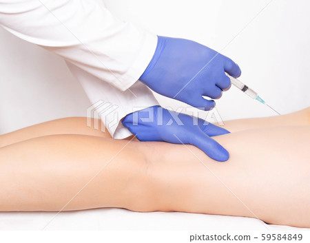 Doctor cosmetologist makes rejuvenation beauty injection to the back of the feet to smooth out 59584849