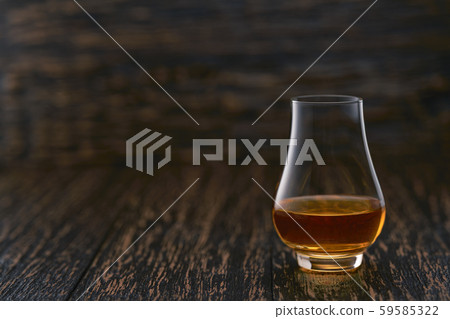 Full glass of whiskey on a wooden table, selective 59585322