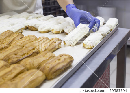 Confectionery for the production of desserts and sweets, making custard cake eclairs with cream and Confectionery for the production of desserts and sweets, making custard cake eclairs with cream and 59585794