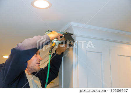 Air nailer tool carpenter using nail gun to crown 59586467