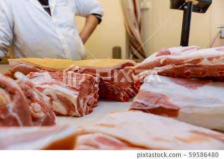 Fresh chopped pieces of meat and male hands of 59586480