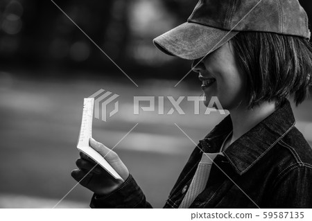Laughing woman looking at bankbook Laughing woman looking at bankbook 59587135