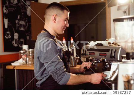 Barista makes espresso in cafe. Barista grind beans with coffee machine. 59587257