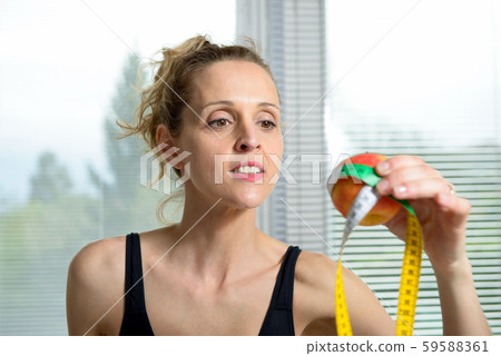 pretty fitness woman with measure tape and apple 59588361