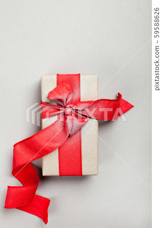 elongated gift box with a red ribbon on a gray background 59588626