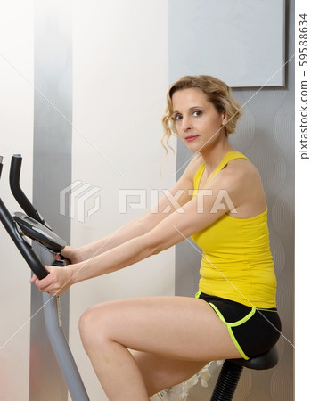 Fit woman on exercise bike  at home 59588634