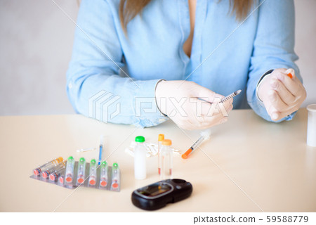 Docto fills a syringe for insulin injections. Diabetes. The shortacting insulin. Insulin injection 59588779