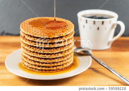 Waffles with hot maple syrup.Honey pouring on a fresh waffles. 59589228