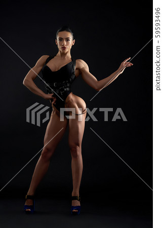 Muscular, attractive woman standing, posing in studio. 59593496