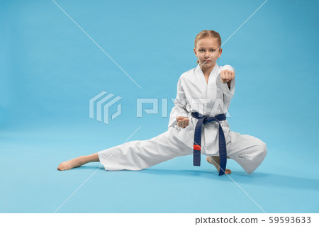 Karate girl standing in stance and training punching. 59593633
