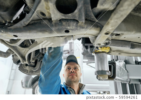 Close up of car's bottom with man who checking transmission Close up of car's bottom with man who checking transmission 59594261