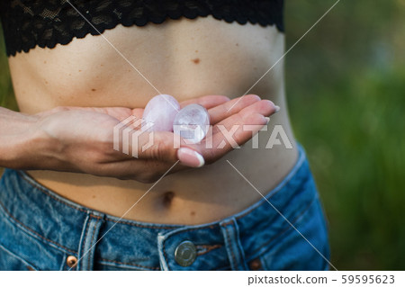 Female hands holding two yoni eggs for vumfit, imbuilding or meditation are made from pink quartz Female hands holding two yoni eggs for vumfit, imbuilding or meditation are made from pink quartz 59595623