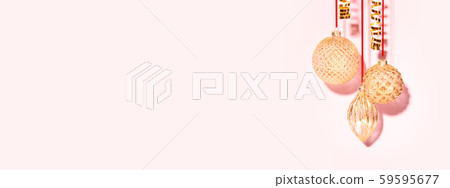Three golden Christmas baubles on the pink background. 59595677