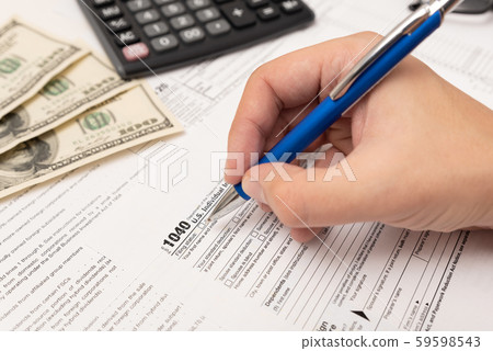 Man filling US tax form in office Man filling US tax form in office 59598543