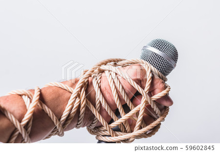Hand holding microphone and have roped on fist 59602845
