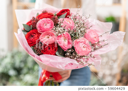 Beautiful bouquet of mixed flowers in womans hands. the work of the florist at a flower shop Beautiful bouquet of mixed flowers in womans hands. the work of the florist at a flower shop 59604429