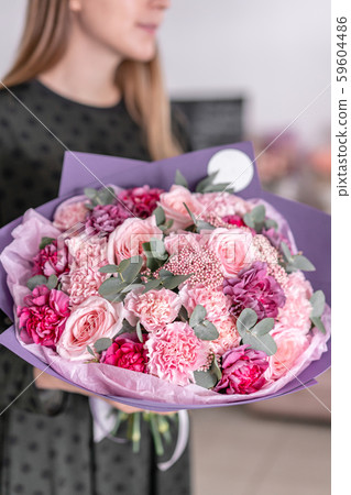 Beautiful bouquet of mixed flowers in womans hands. the work of the florist at a flower shop 59604486