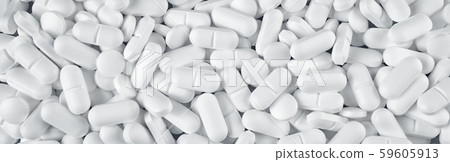 White pills spilled on blue wooden background 59605913