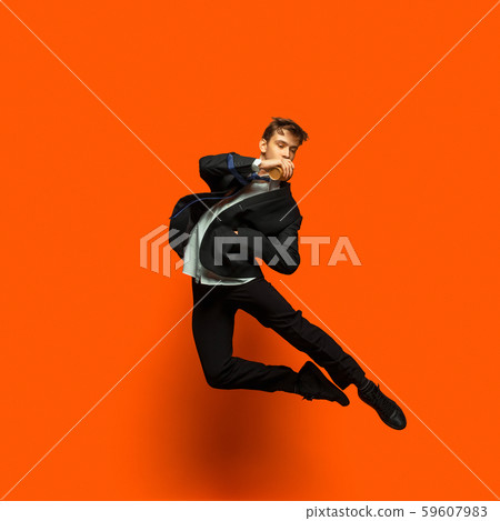 Man in casual office style clothes jumping isolated on studio background Man in casual office style clothes jumping isolated on studio background 59607983