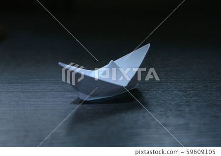 white paper boat on a dark table white paper boat on a dark table 59609105
