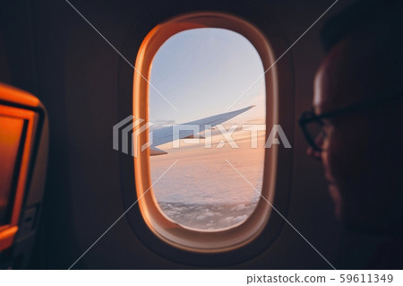 Man looking throught vindow of airplane 59611349