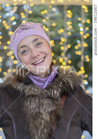 smiling young woman wearing winter clothes celebrating Christmas at the street with sparklers. Empty 59612067
