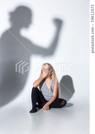 Sad and frightened little girl with bloodshot and bruised eyes sitting scared 59612872