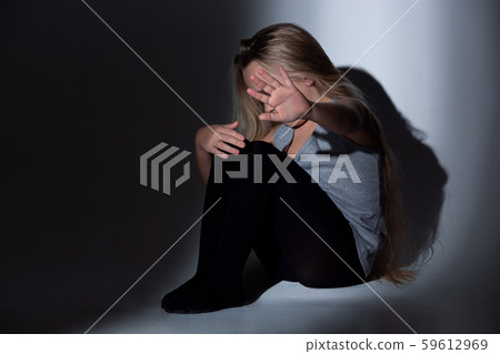 Sad and frightened little girl with bloodshot and bruised eyes sitting scared Sad and frightened little girl with bloodshot and bruised eyes sitting scared 59612969