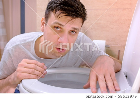 Sickness man vomit in toilet sitting on floor looking at camera having flu. 59612979